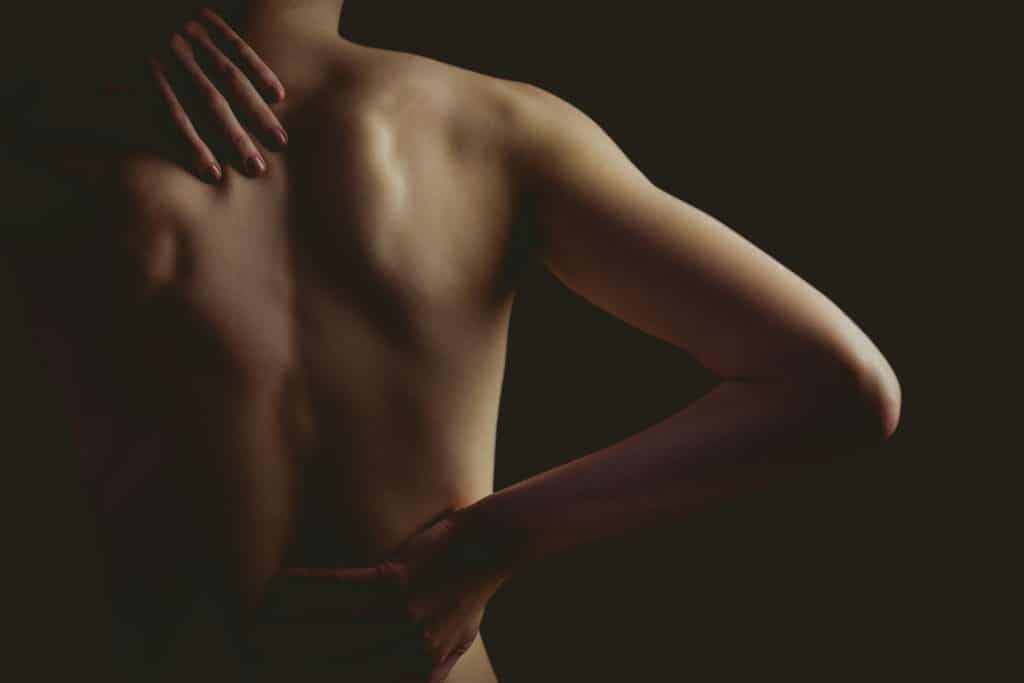 woman with a back injury on black background