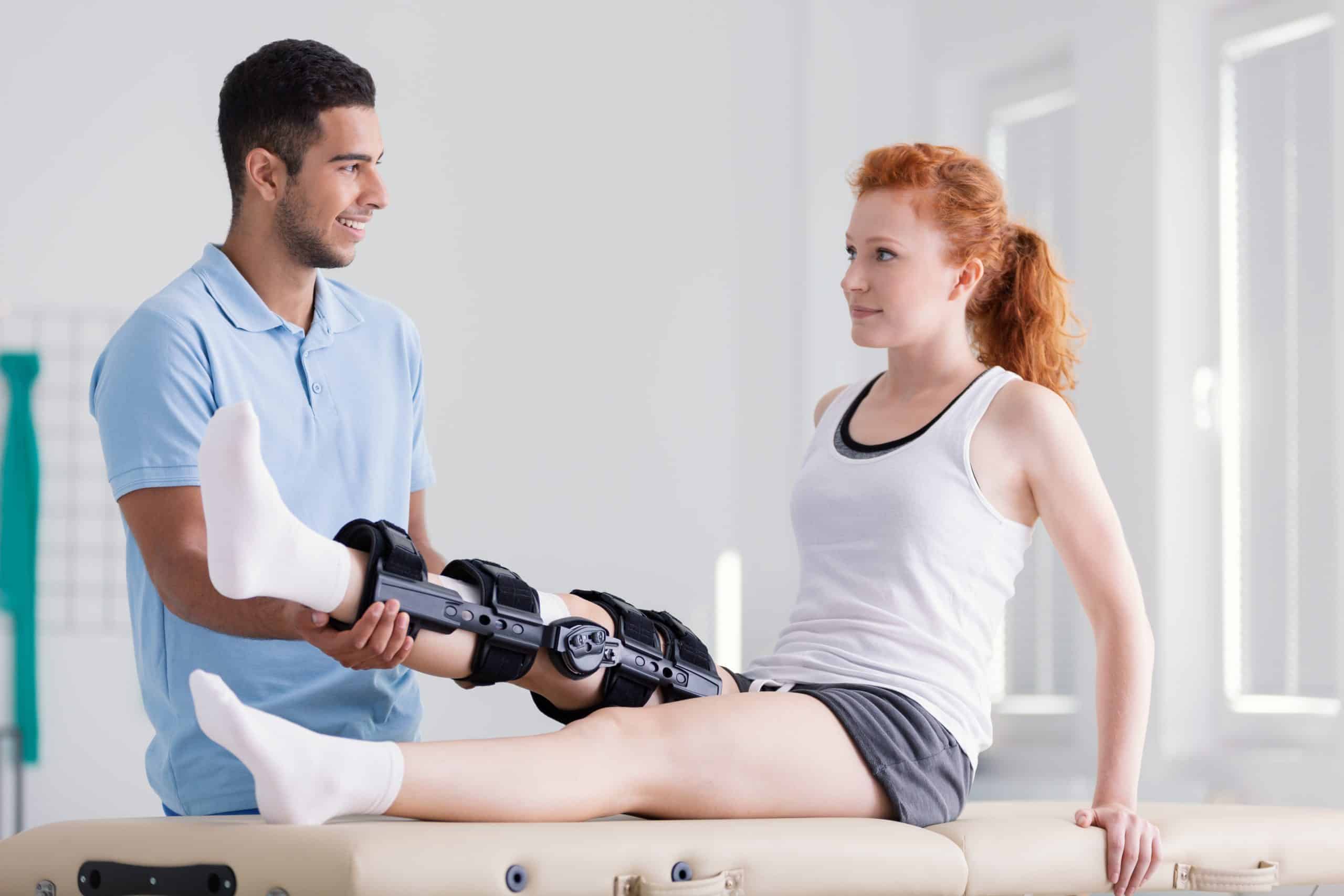 Young woman wearing a brace during rehabilitation with her physiotherapist